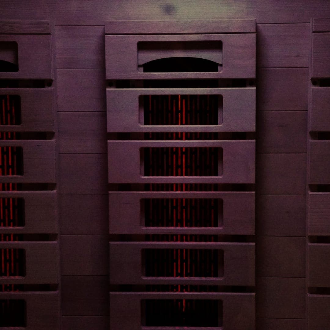 Infrared sauna heater panels glowing red under chromotherapy lighting